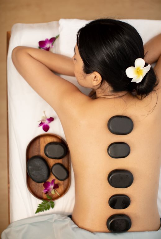 A customer receiving a hot stone massage at Makkha Health & Spa