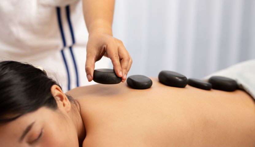 Our therapist placing heated stones on a customer’s back