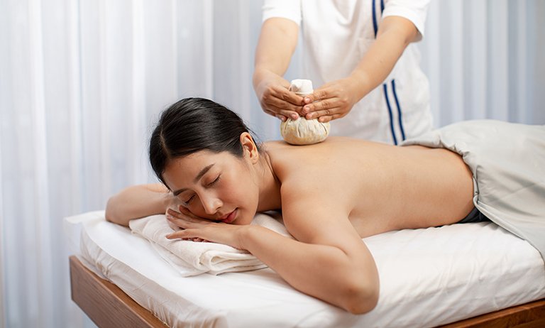 A customer receiving a Thai herbal massage at Makkha Health & Spa