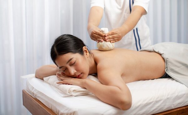 A customer receiving a Thai herbal massage at Makkha Health & Spa